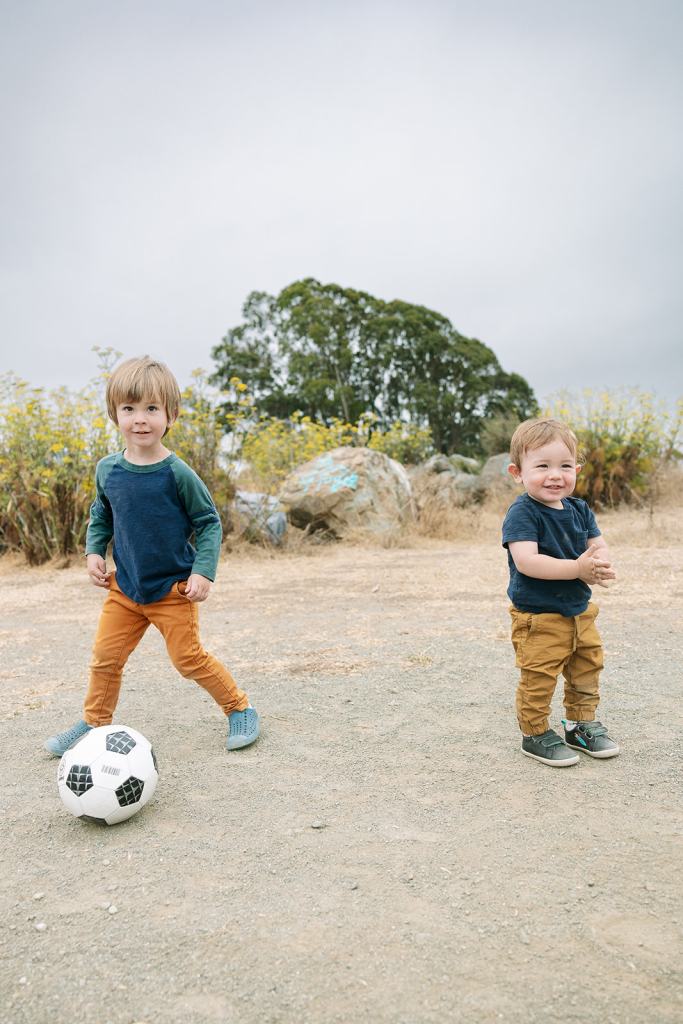 brothers playing with soccer ball on the beach at the albany bulb
