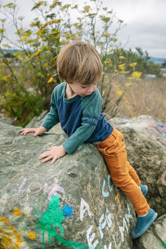 Little boy climbing rocks at Albany Bulb