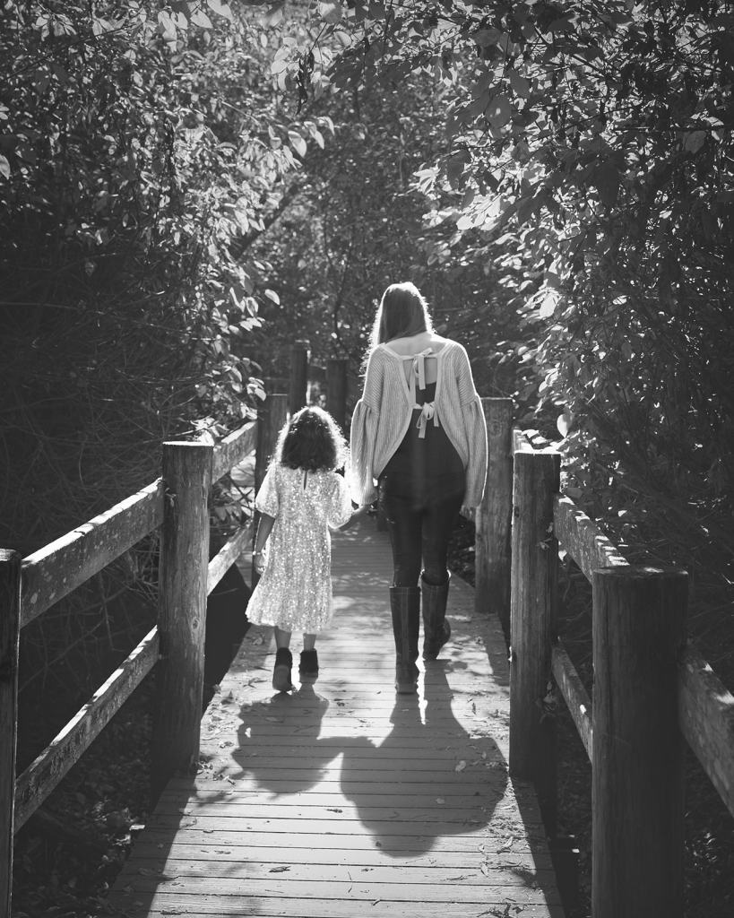 Mother and daughter walking down wooden path in Tilden Park Berkeley CA