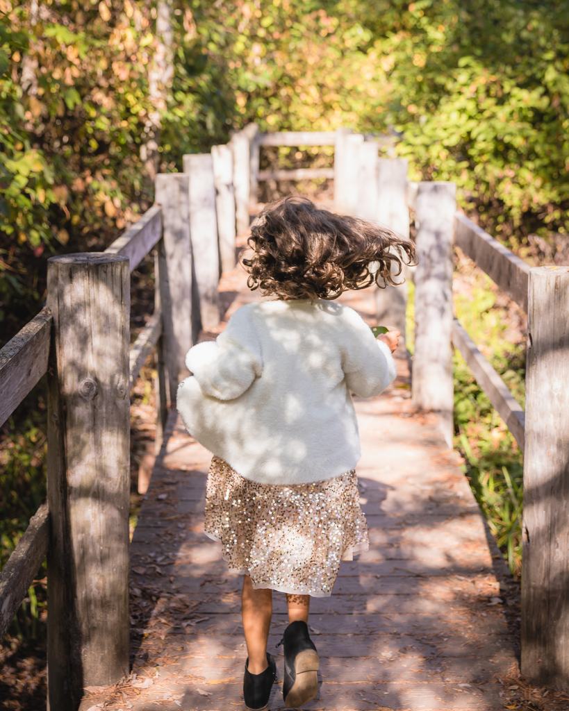 Little girl running along wooden path in Tilden Park Berkeley California 