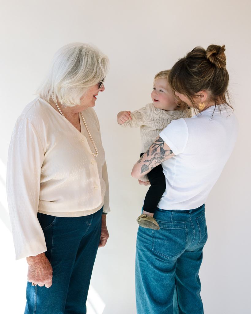 Grandmother, mother, and toddler son posing for studio motherhood photo session