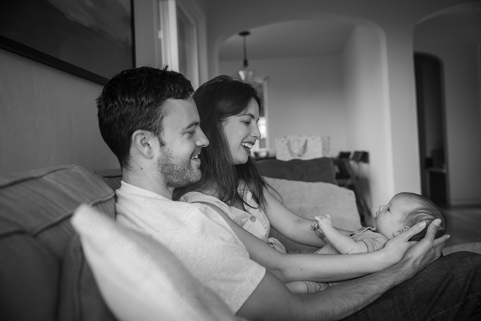 Parents holding baby in living room