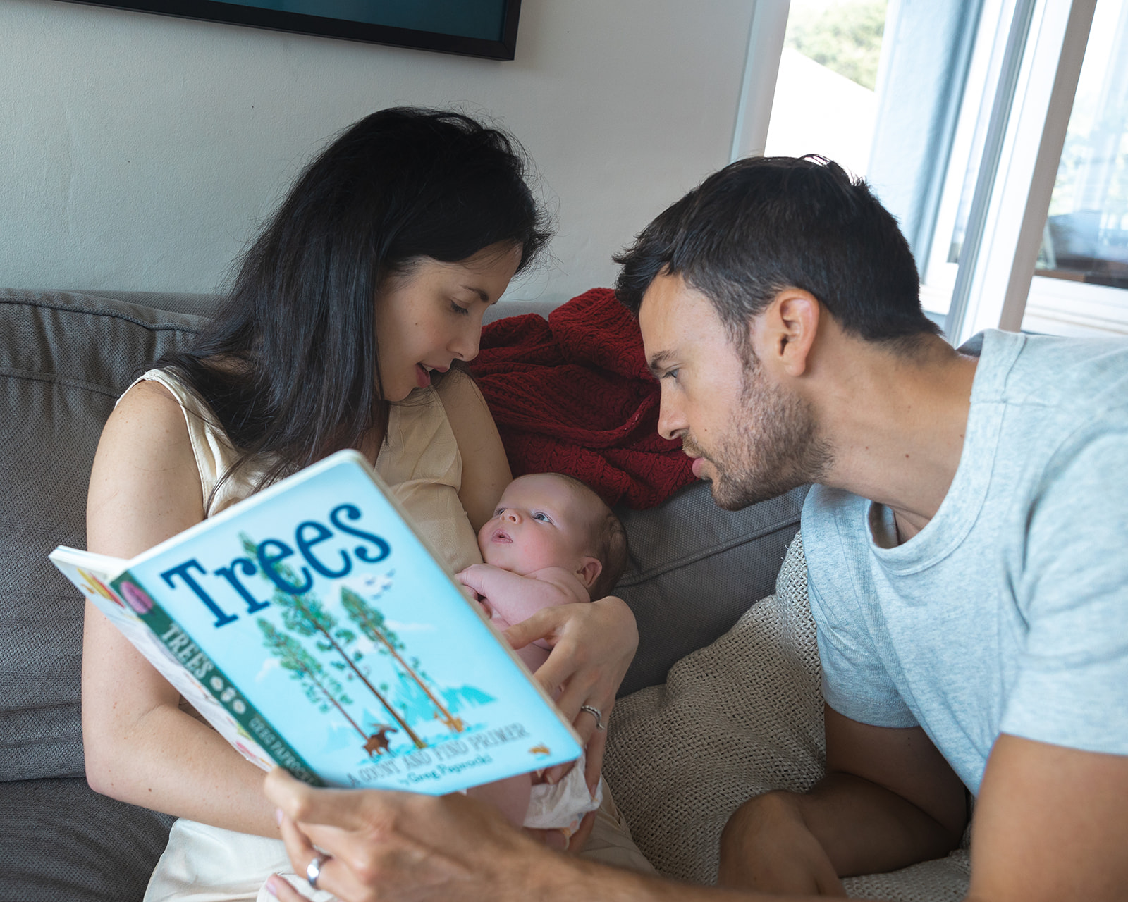 Mother and father reading baby a book