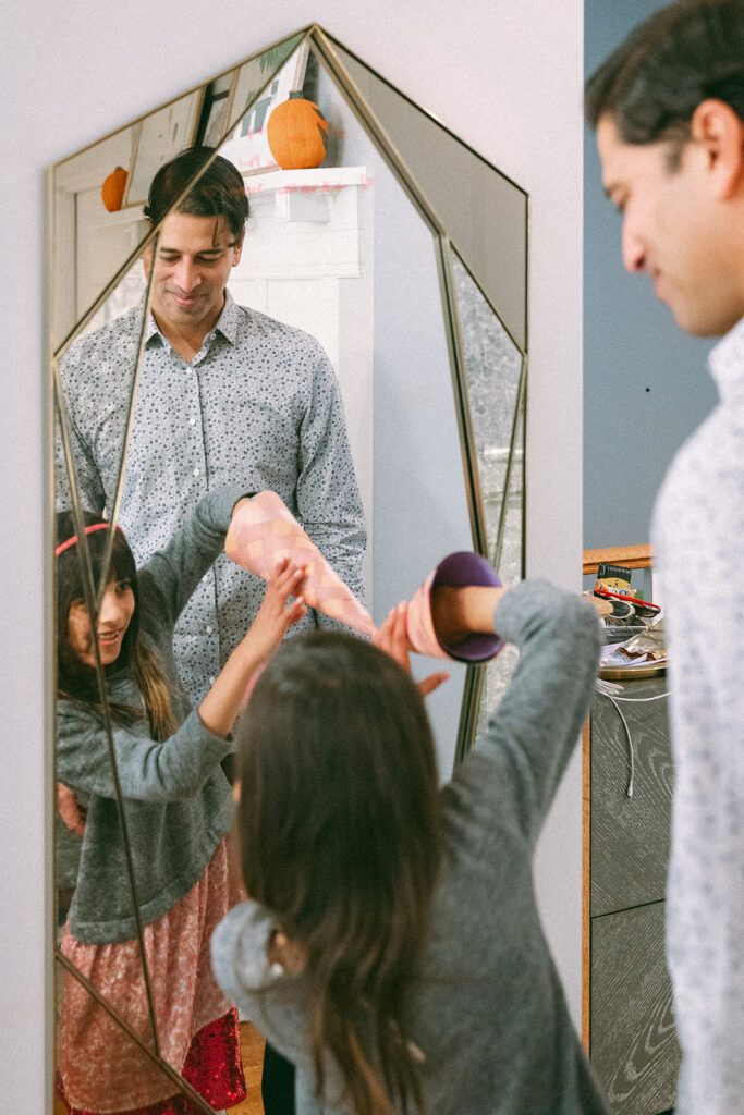 Daughter and father looking at themselves in the mirror