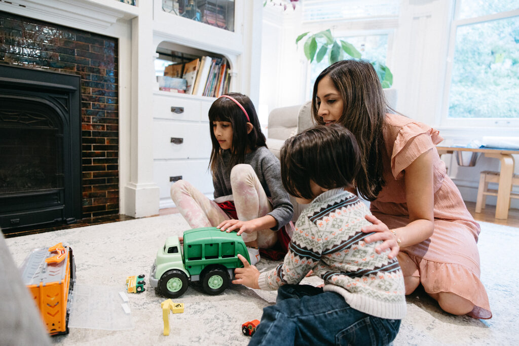 Family playing with toys in their living room during at home family photoshoot in San Francisco
