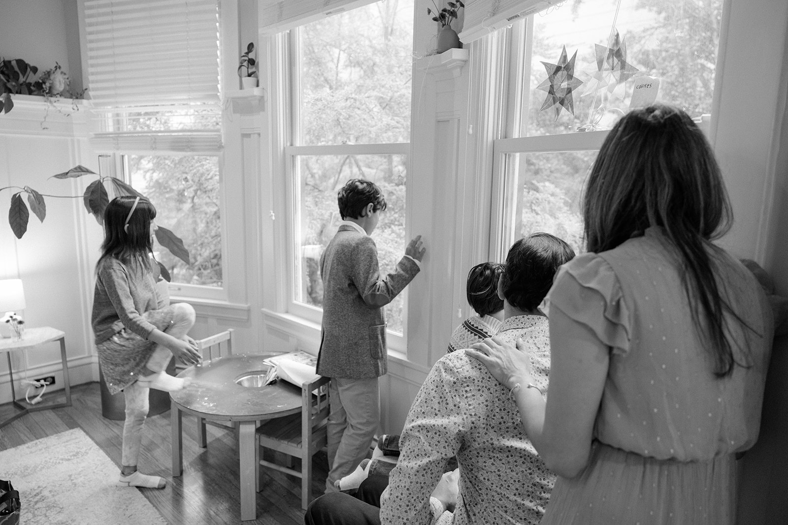 Family of five looking out the window during their at home family photoshoot in San Francisco