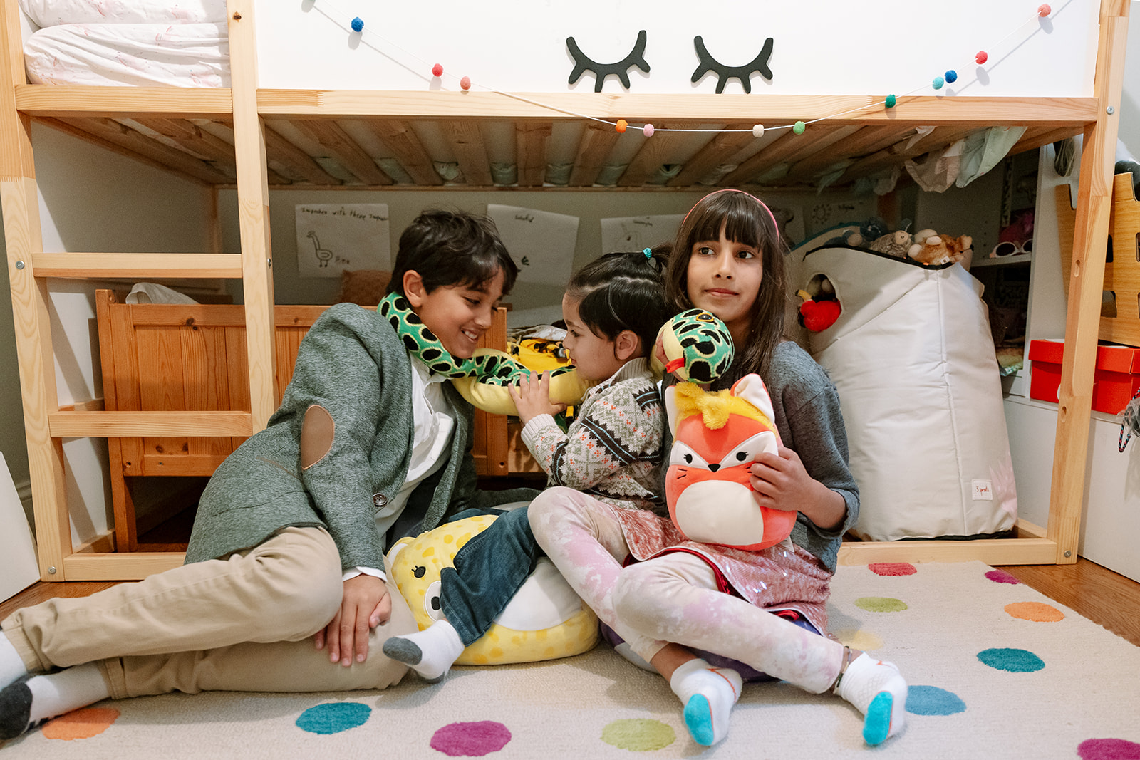 Three siblings sitting on their bedroom floor