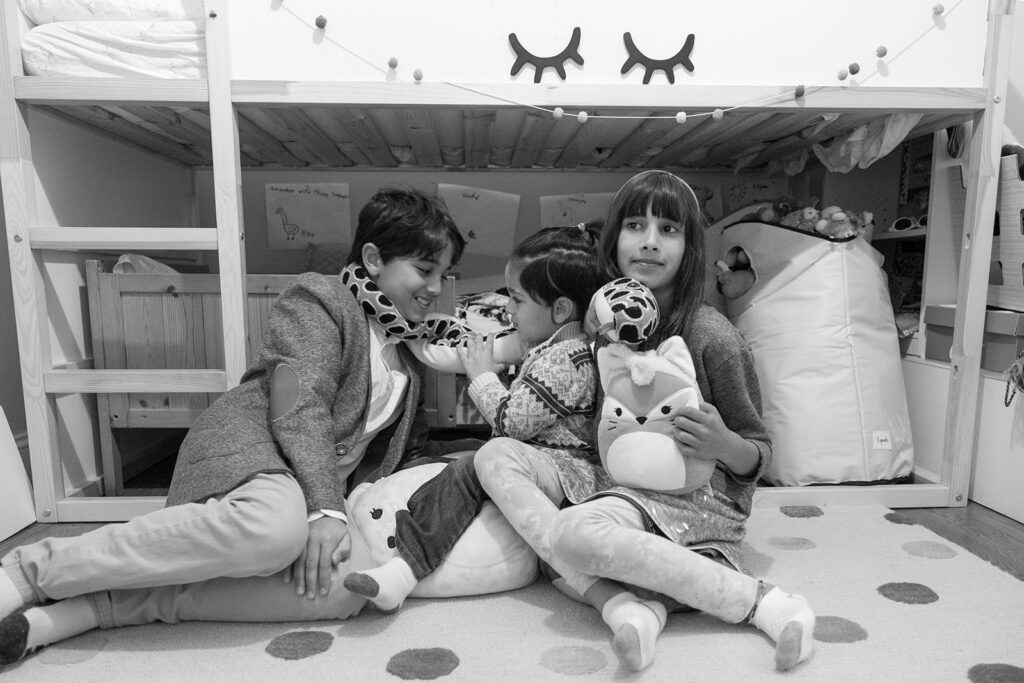 Siblings sitting on their bedroom floor