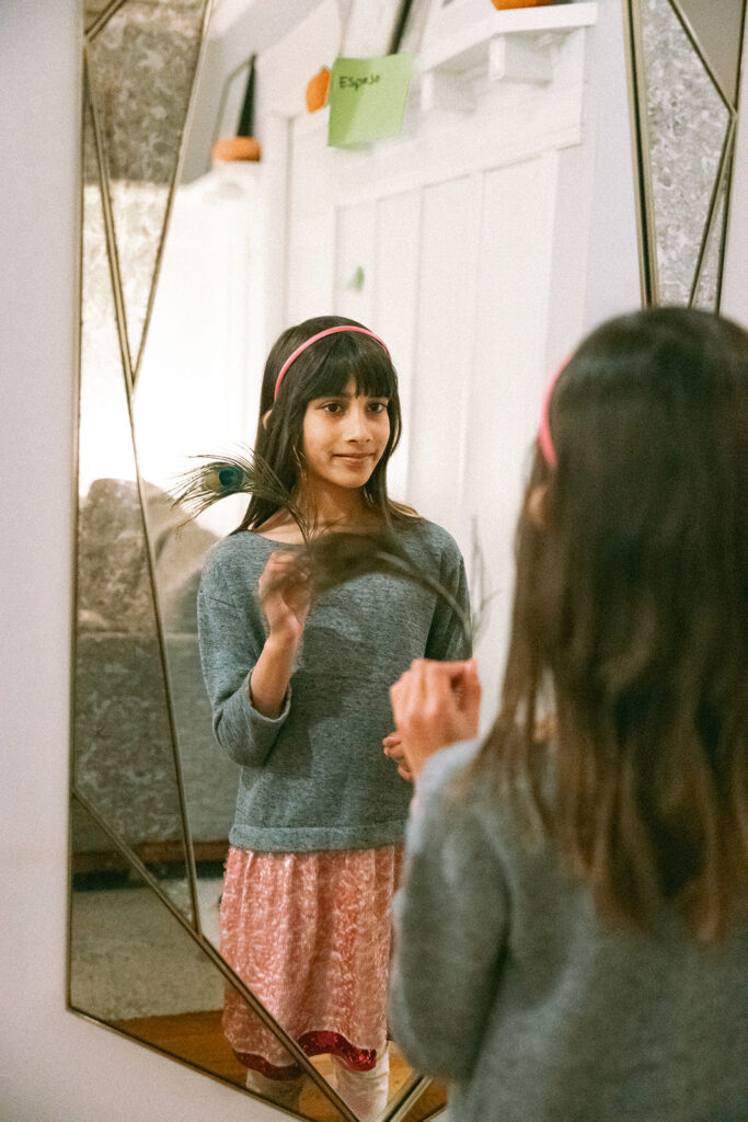 Little girl looking at herself in the mirror