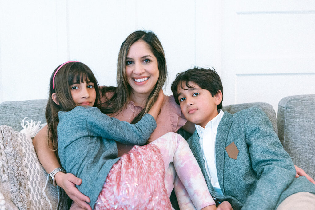 Mother, daughter and son sitting on a couch together during at home family photoshoot in San Francisco