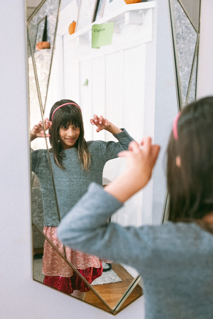 Girl looking at herself in the mirror