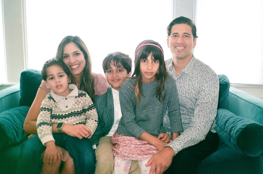 Family sitting on a couch for their at home family photoshoot in San Francisco on 35mm film