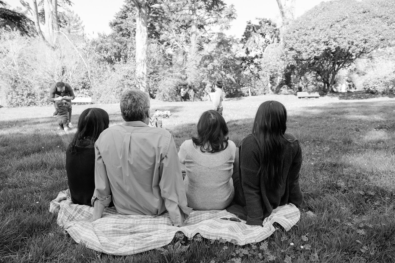 Family sitting in the San Francisco Botanical Gardens during their family photo session