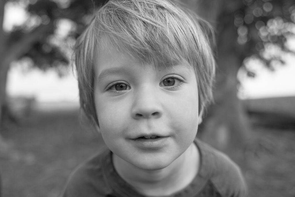Black and white close up photo of a little boy