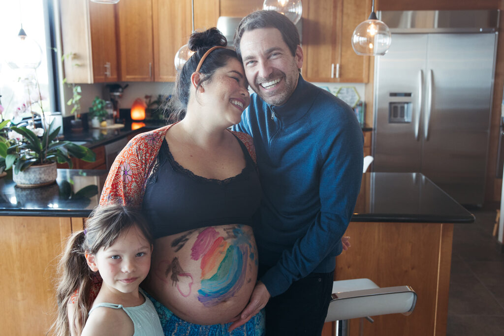 Family of three posing for photos during at home maternity session in the Bay Area