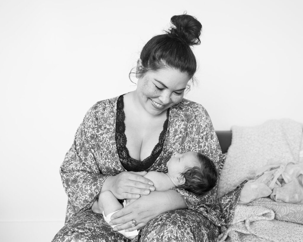 Black and white photo of a mother holding baby during an at home newborn session the Bay Area