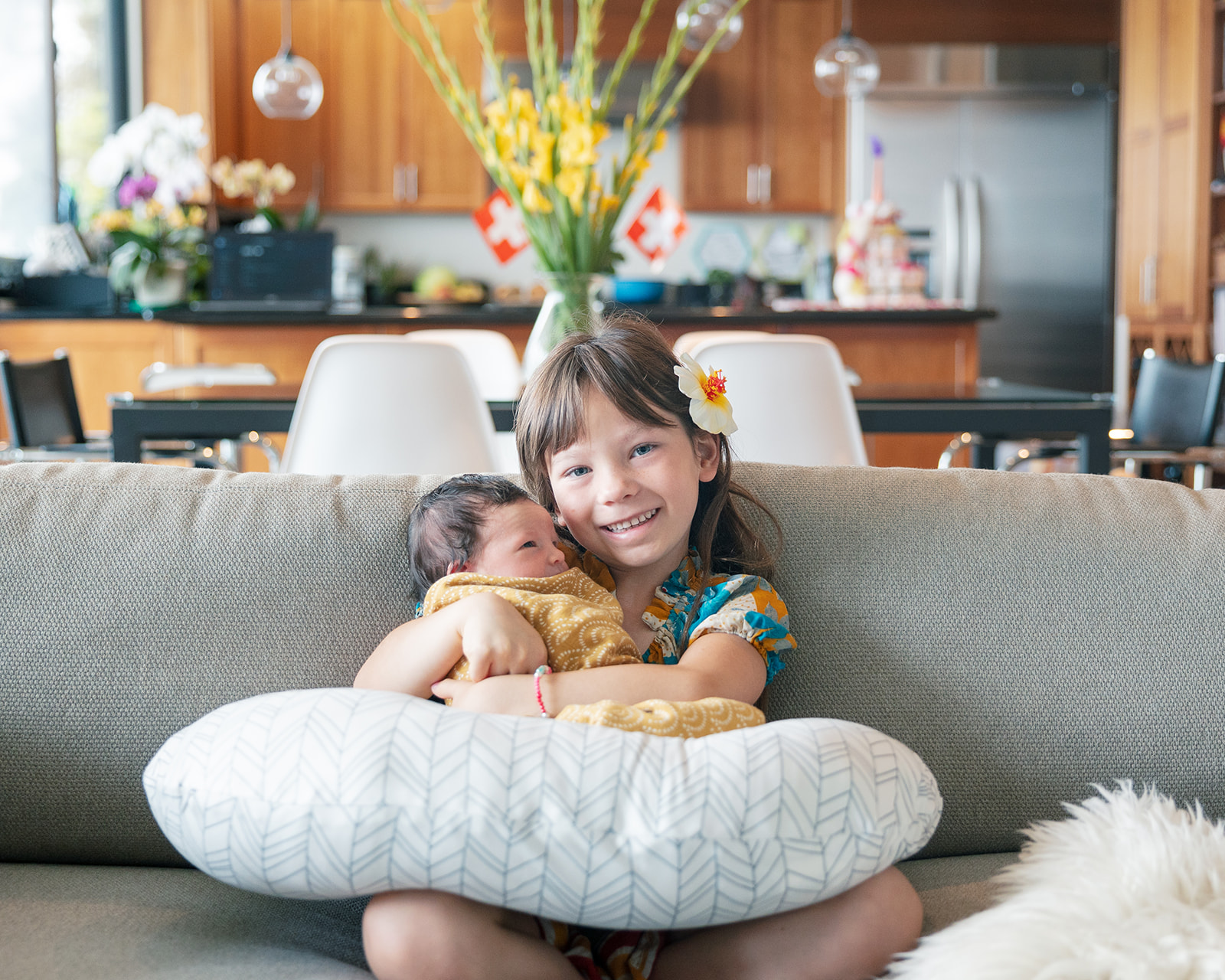 Big sister holding her newborn sister during Bay Area newborn session