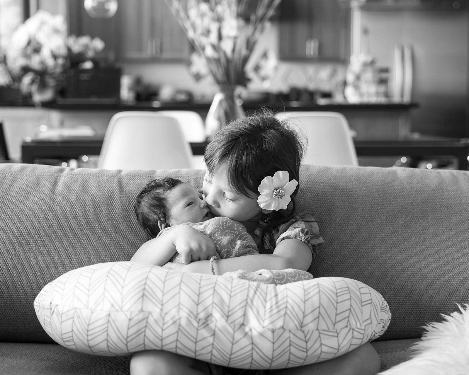 Big sister holding her newborn sister during at home newborn session in the Bay Area