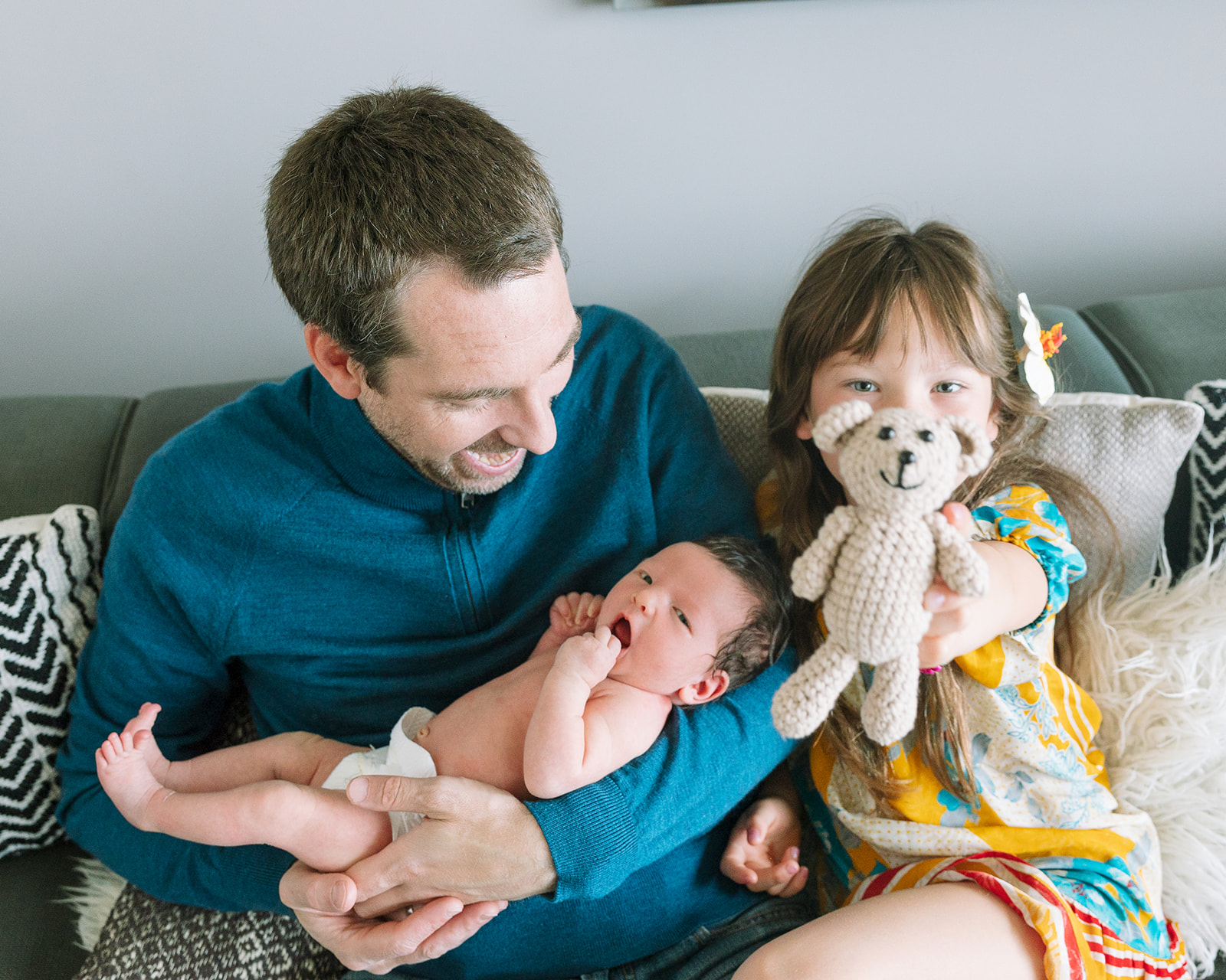 photo of father, newborn daughter, and older sister during at home newborn session