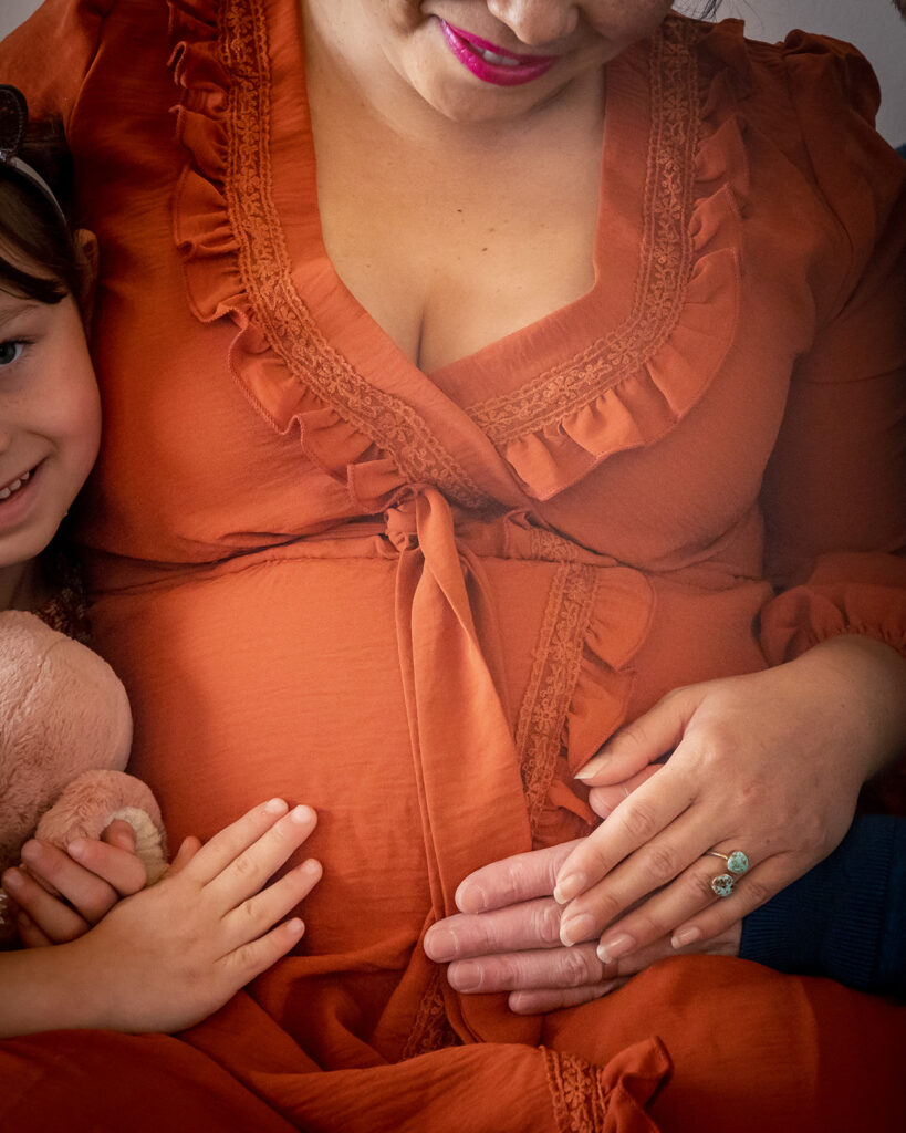 Pregnant mother, father, and daughter during at home maternity session