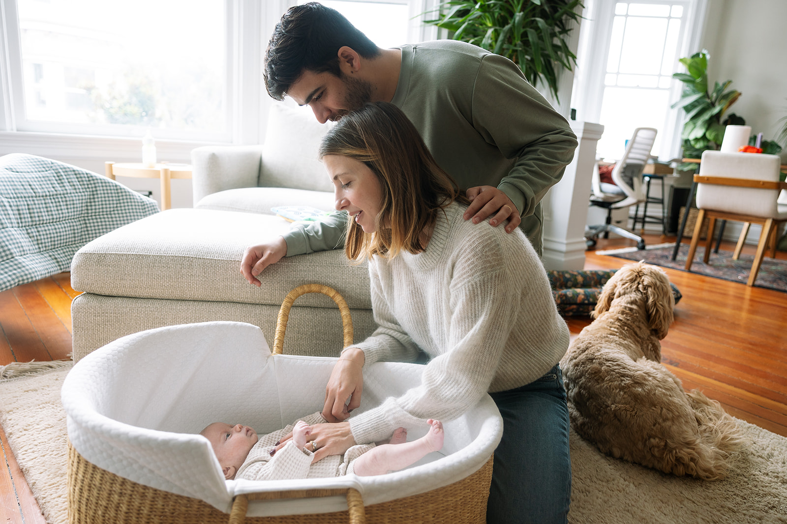 Mother and father admiring their baby during their at-home San Francisco newborn photoshoot
