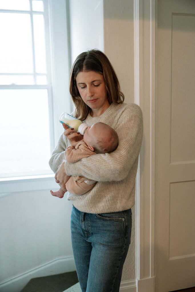 Mother feeding her newborn baby during their lifestyle at-home San Francisco newborn photoshoot