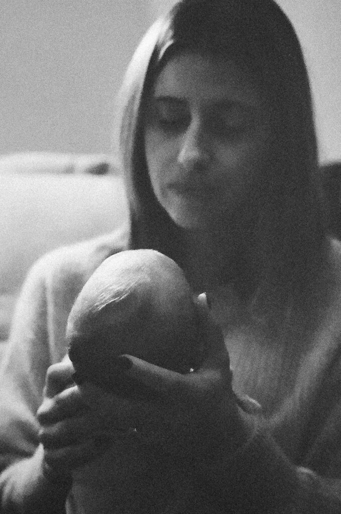 Black and white photo of a mother holding her newborn baby during their at-home San Francisco newborn photoshoot