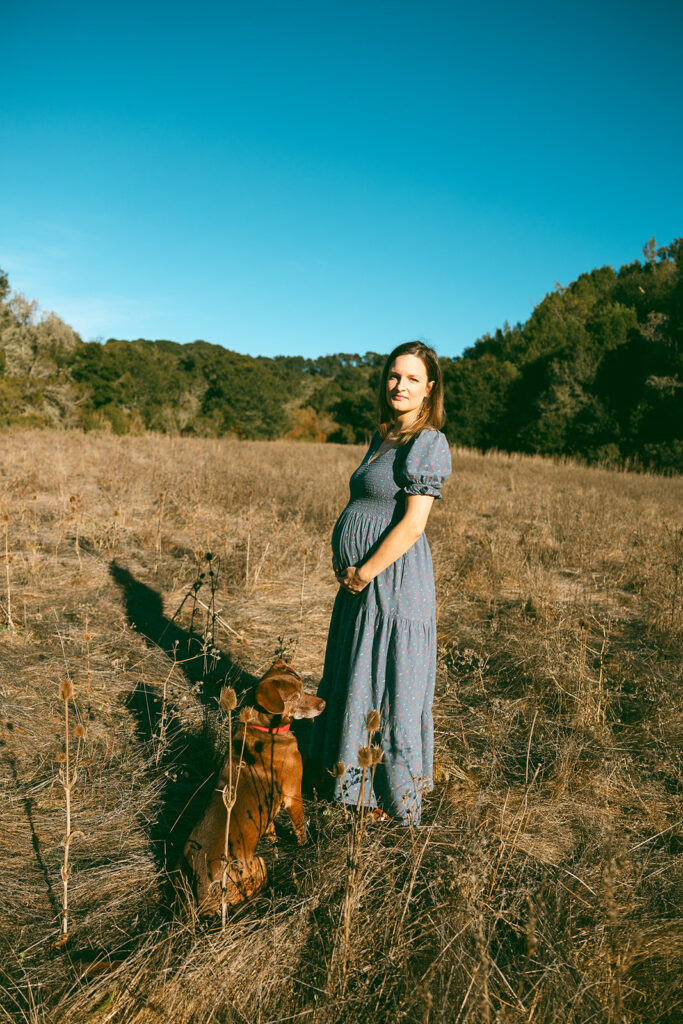 A pregnant woman and her dog at Tilden Regional Park in Berkeley, CA during her maternity & family pictures