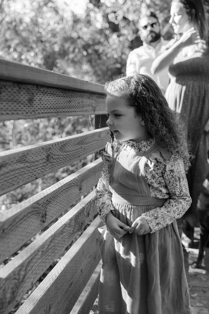 Black and white photo of a little girl and her parents at Tilden Regional Park in Berkeley, CA for their maternity & family pictures