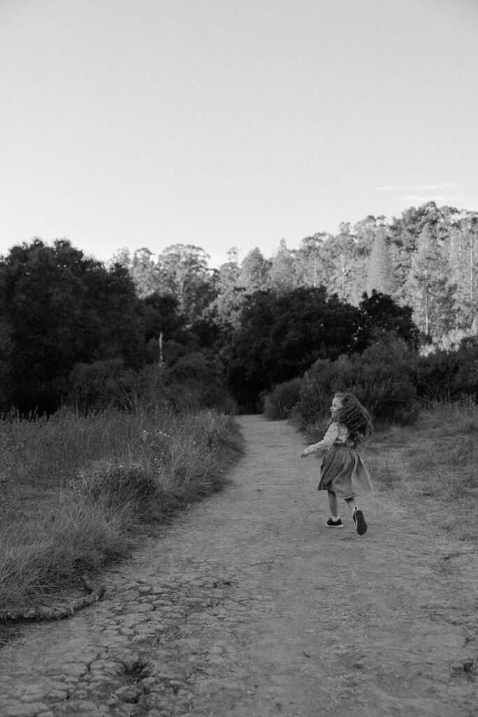 Black and white photo of a girl running the trails at Tilden Regional Park in Berkeley, CA.