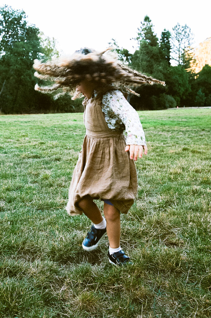 Little girl dancing in the grass on 35mm film