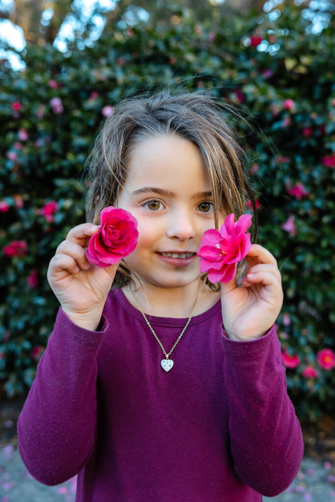 Little girl holding flowers up