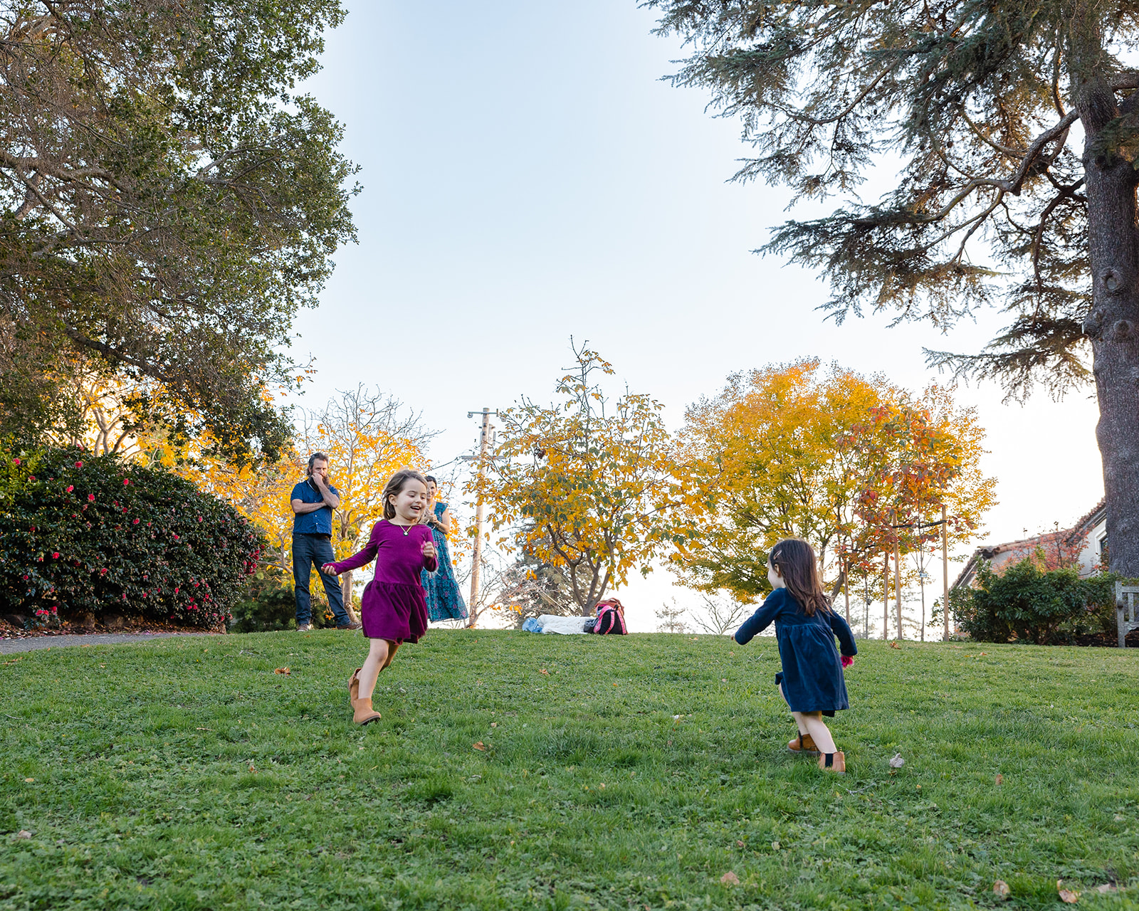 Family of four having fun during their fall family photo session at Piedmont Park in the East Bay of California