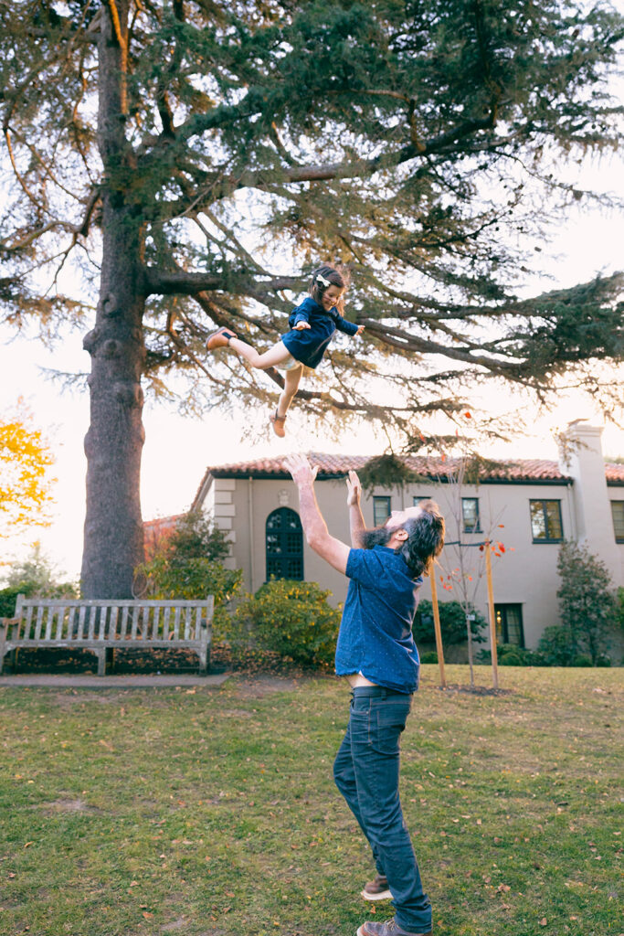 Father throwing his toddler daughter up in the air