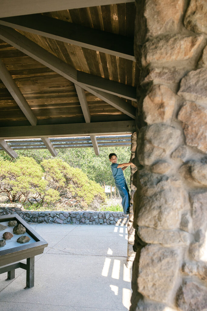 Young boy climbing a rock wall in a park