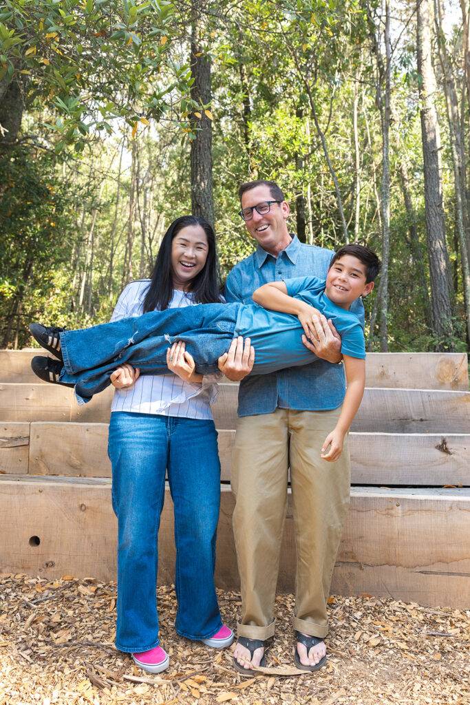 Mother and father holding their son up sideways during their playful Oakland CA family photos at Sibley Regional Park