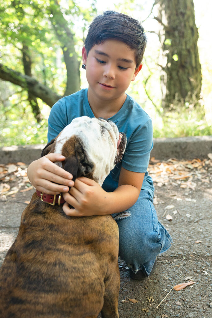 Young boy petting his dog during his outdoor family session