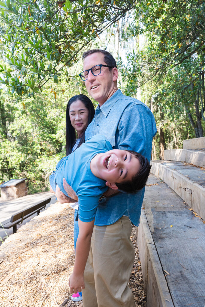 Mother and father holding their son up sideways during their playful Oakland CA family photos at Sibley Regional Park