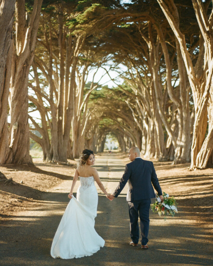 Couple walking along the Cypress Tree Tunnel for their intimate Point Reyes elopement in Northern California