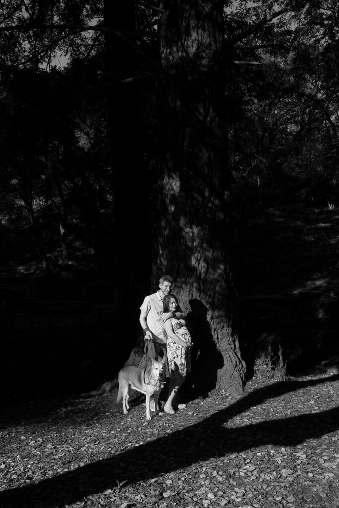 Black and white photo of a man and woman at the park with their dog