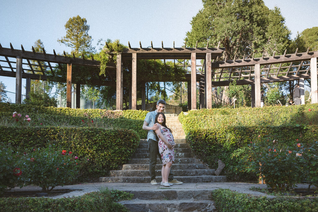 Man and woman posing for their East Bay maternity photography session at Berkeley Rose Garden