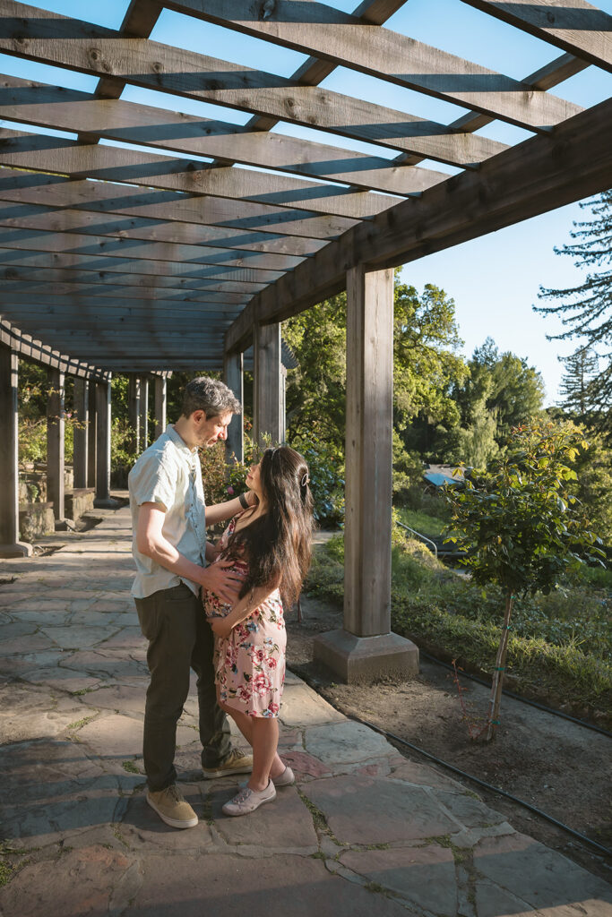 Pregnant woman and man posing for photos at Berkeley Rose Garden