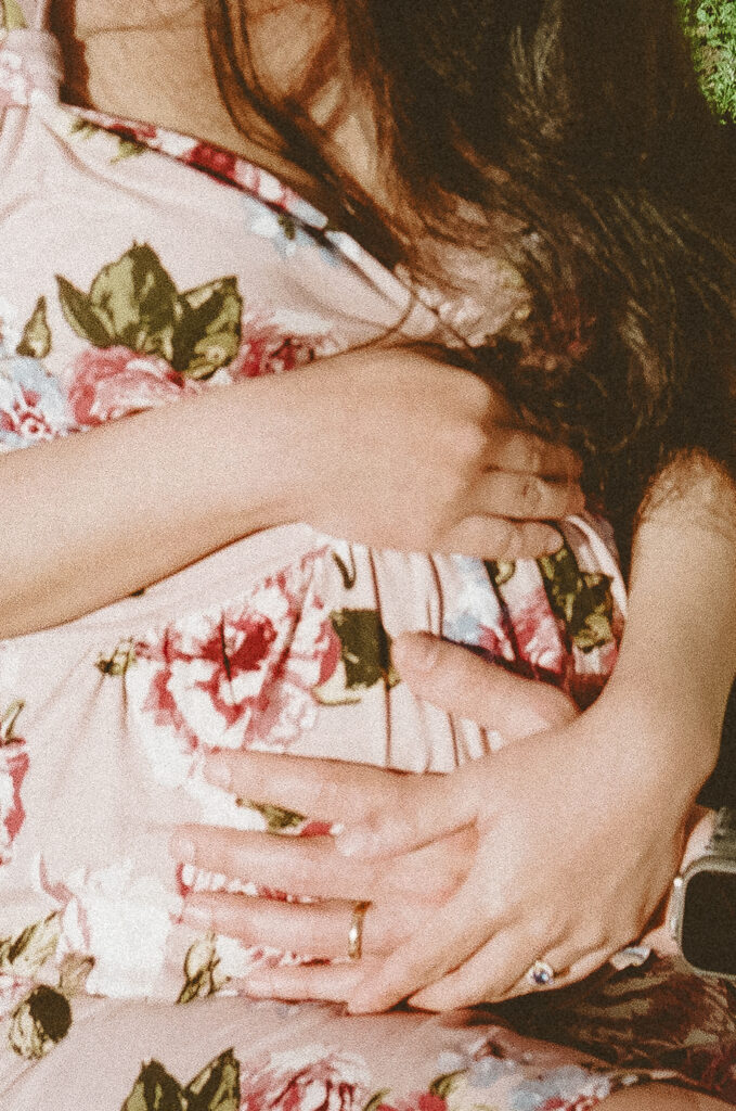 Close up photo of a mother holding her pregnant belly during her East Bay maternity photography session captured on 35mm film