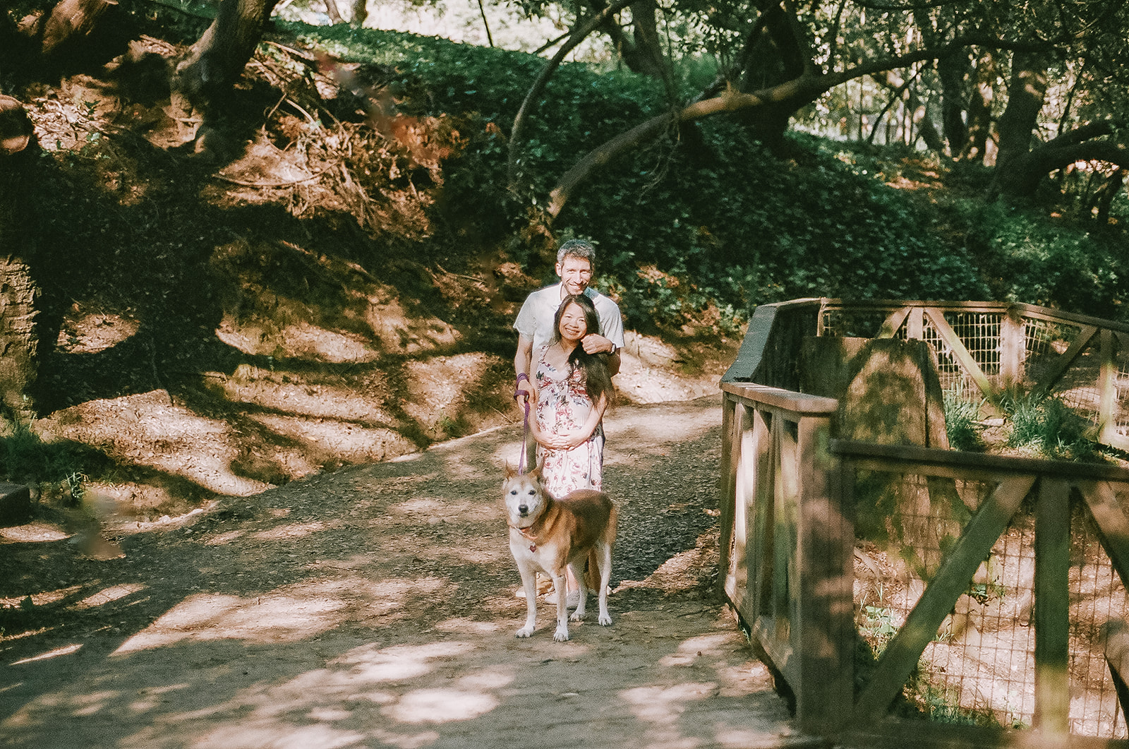 Couple walking in the park with their dog for their East Bay maternity photography captured on 35mm film