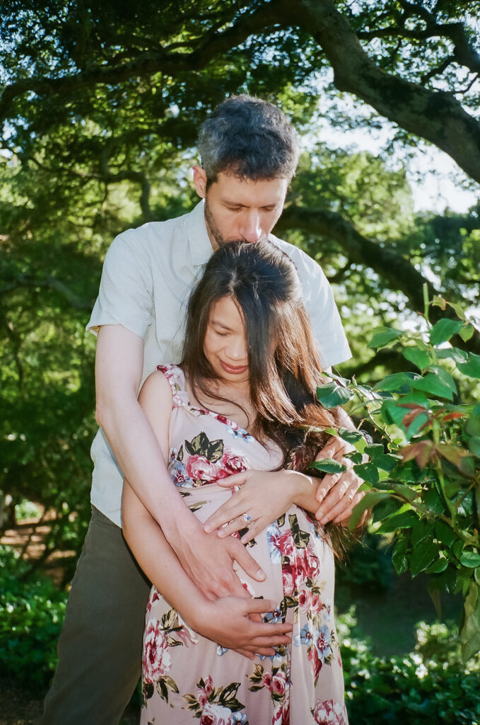 Man holding his pregnant partners belly during their East Bay maternity photography session captured on 35mm film