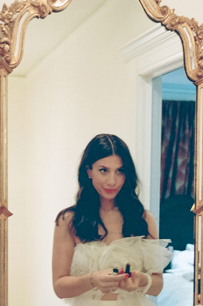 Bride putting lipstick on in the mirror