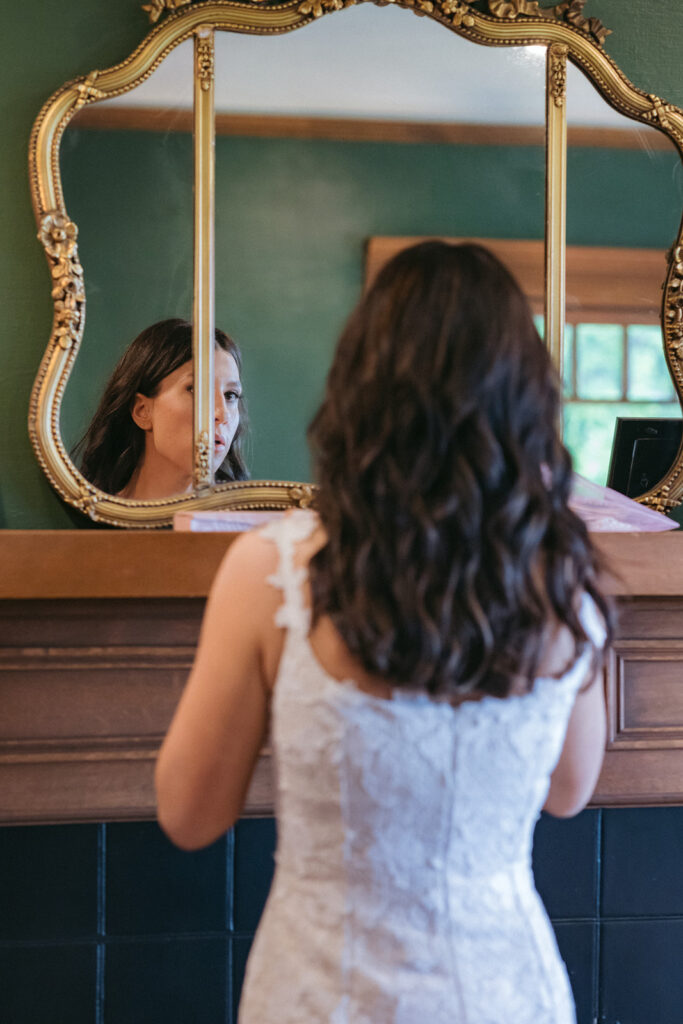 Bride looking at herself in the mirror as she gets ready