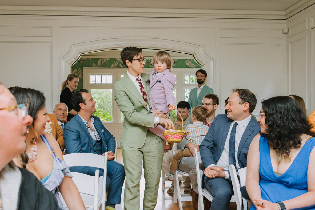 Flower boy being carried down the aisle