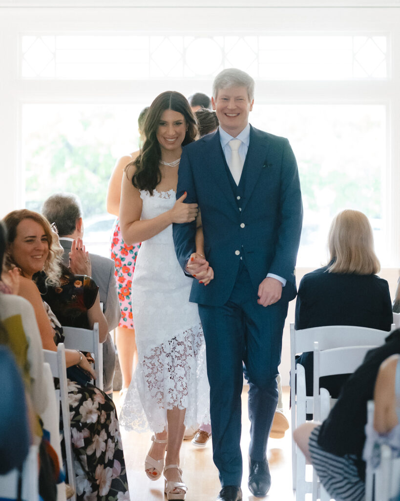 Bride and groom walking back down the aisle together after their intimate at-home East Bay wedding ceremony in Berkeley, California