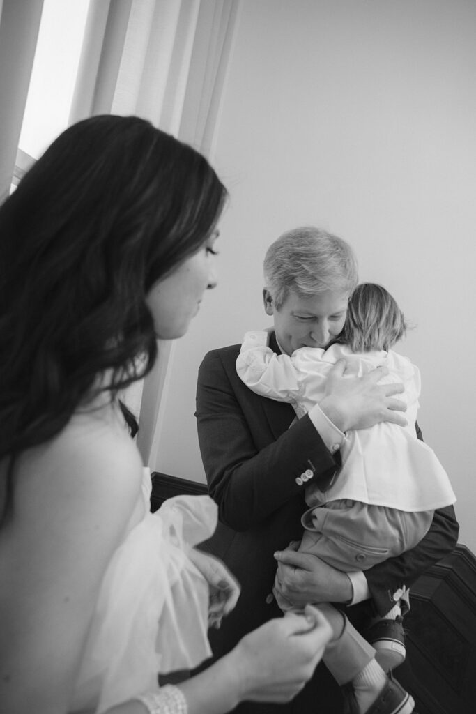 Black and white photo of a groom hugging his son